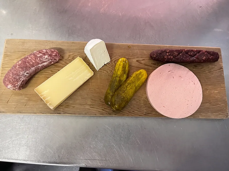 Wurst, Käse und Gurke auf dem Holzbrett