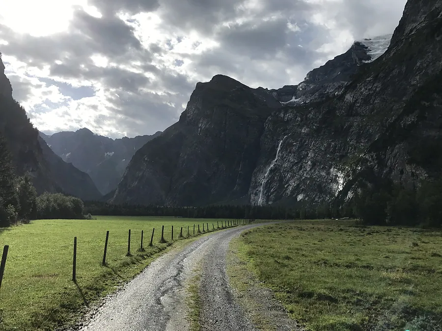 Die Naturstrasse im Talboden unter Regenwolken