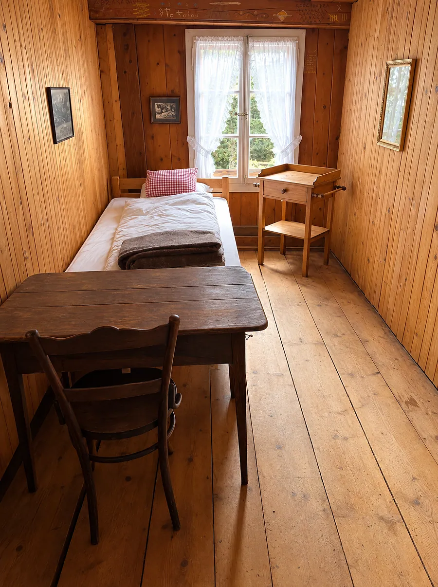 Schmales Zimmer mit Schreibtisch am Fenster